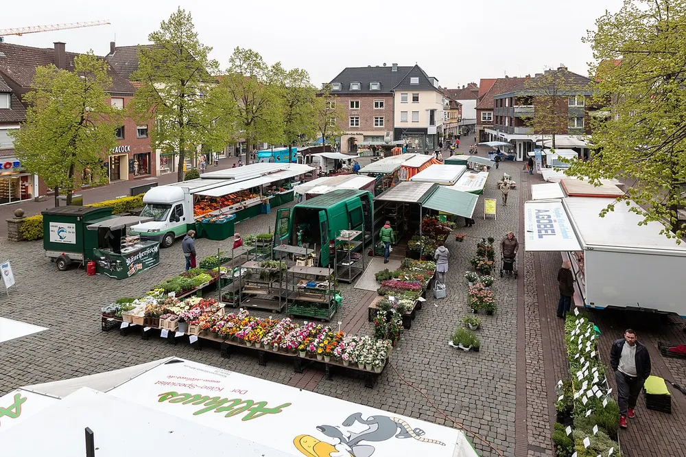 Wochenmarkt auf dem Marktplatz in Dülmen: Marktstände mit Obst und Gemüse, davor Besucherinnen und Besucher